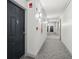 Well-lit hallway with neutral carpet and paint, featuring unit entrance and fire safety equipment at 1280 W Peachtree Nw St # 2205, Atlanta, GA 30309