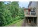 Spacious backyard featuring a deck with a grill, overlooking lush greenery and trees at 13067 Overlook Pass, Roswell, GA 30075