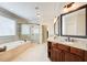 Elegant bathroom featuring a soaking tub, glass-enclosed shower, and dual vanities with granite countertops at 13067 Overlook Pass, Roswell, GA 30075