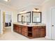 Bathroom featuring double sinks, with granite countertops, dark wood cabinets, and a walk-in closet at 13067 Overlook Pass, Roswell, GA 30075