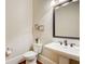 Charming half-bathroom features pedestal sink, decorative mirror, and hardwood floors at 13067 Overlook Pass, Roswell, GA 30075