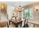 Elegant dining room with hardwood floors, a decorative chandelier, and a large window, perfect for entertaining at 13067 Overlook Pass, Roswell, GA 30075