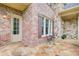 Detailed view of the home's exterior with brick and stone accents, showcasing a cozy seating area on the patio at 13067 Overlook Pass, Roswell, GA 30075