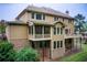 Two-story tan home with brick foundation, screened porch and deck in a wooded area at 13067 Overlook Pass, Roswell, GA 30075