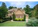 Charming two-story home with a brick and siding exterior, complemented by a well-manicured lawn and lush landscaping at 13067 Overlook Pass, Roswell, GA 30075