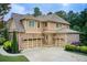 Side view of a three-car garage with brick and siding exterior, with ample parking and well-maintained landscaping at 13067 Overlook Pass, Roswell, GA 30075