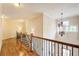 Upstairs hallway features hardwood flooring, decorative railings, and a modern chandelier at 13067 Overlook Pass, Roswell, GA 30075