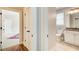 Hallway view of doors, closet, and entry to bathroom with a granite counter vanity at 13067 Overlook Pass, Roswell, GA 30075