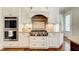 Well-equipped kitchen boasts stainless steel appliances, granite counters, and custom hood at 13067 Overlook Pass, Roswell, GA 30075