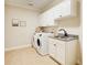 Convenient laundry room with granite counters, cabinetry, sink, and modern appliances at 13067 Overlook Pass, Roswell, GA 30075
