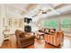 Cozy living room with built-in shelving, a fireplace, comfortable seating, and natural light from large windows at 13067 Overlook Pass, Roswell, GA 30075