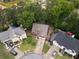 Aerial view of a brick home on a cul-de-sac lot surrounded by lush greenery and neighboring houses at 565 Saint James Ct, Lawrenceville, GA 30044