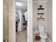 Bathroom leading to a walk-in closet, featuring floating shelves and a toilet at 565 Saint James Ct, Lawrenceville, GA 30044