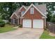 Charming brick home featuring a two-car garage, manicured lawn, and classic architectural details at 565 Saint James Ct, Lawrenceville, GA 30044