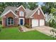 Charming two-story brick home with a well-manicured lawn and a two-car garage at 565 Saint James Ct, Lawrenceville, GA 30044