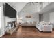 Bright and airy living room featuring a stone fireplace, vaulted ceilings, and a large sectional sofa at 565 Saint James Ct, Lawrenceville, GA 30044