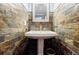 Stylish powder room featuring a pedestal sink and unique stone accent wall at 656 Gunby Se Rd, Marietta, GA 30067