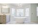 Bright bathroom featuring a soaking tub with large windows providing a view of the outdoors at 656 Gunby Se Rd, Marietta, GA 30067
