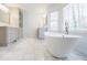 Large luxurious bathroom with freestanding tub, marble floors and natural light at 656 Gunby Se Rd, Marietta, GA 30067
