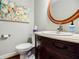 Charming powder room features a round mirror, attractive vanity, and toilet at 656 Gunby Se Rd, Marietta, GA 30067