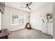 Bedroom featuring a ceiling fan, large window, neutral carpet, and white walls at 1543 Blossom Dr, Atlanta, GA 30349