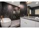 Modern bathroom featuring black marble, gold fixtures, a free-standing tub, and a walk-in shower at 1721 S Gordon Sw St, Atlanta, GA 30310