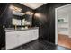 Modern bathroom featuring black marble, gold fixtures, and a view of the walk-in closet at 1721 S Gordon Sw St, Atlanta, GA 30310