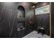 Elegant shower with black marble tile and bronze fixtures, complete with built-in shelving at 1721 S Gordon Sw St, Atlanta, GA 30310