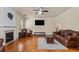 Cozy living room with a fireplace, hardwood floors, and comfortable seating area at 3547 Edenridge Ct, Buford, GA 30519