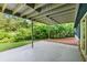 Concrete back patio under a deck with pillars and sliding doors to the interior at 3861 Foxford Dr, Atlanta, GA 30340