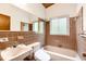 Tiled bathroom featuring a bathtub, large mirror, and vanity with a sink at 3861 Foxford Dr, Atlanta, GA 30340