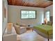 Bright bedroom features a bed, chair, and light wood floors under wood plank ceilings at 3861 Foxford Dr, Atlanta, GA 30340