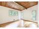 Inviting bedroom features light hardwood floors, and a wood plank ceiling under three windows at 3861 Foxford Dr, Atlanta, GA 30340