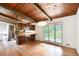 An open layout with wood ceiling and hardwood floors. Stainless steel refrigerator in the kitchen is visible at 3861 Foxford Dr, Atlanta, GA 30340