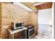 Kitchenette featuring stainless steel appliances, brick walls, and a tiled floor near balcony at 3861 Foxford Dr, Atlanta, GA 30340