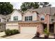 Charming townhome featuring a brick facade, attached garage, and well-maintained landscaping at 1603 Glen Ivy, Marietta, GA 30062