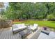 A spacious backyard with a deck featuring white outdoor furniture, trees, and a playset at 2970 Chardonnay Ln, Cumming, GA 30041
