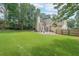 Spacious, grassy backyard with trees, a patio set and fenced perimeter at 2970 Chardonnay Ln, Cumming, GA 30041