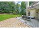 View of a backyard from the deck with outdoor furniture, lawn, and trees at 2970 Chardonnay Ln, Cumming, GA 30041