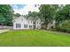 View of a two-story stucco home with manicured lawn and mature shade trees at 2970 Chardonnay Ln, Cumming, GA 30041