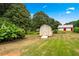 Well-maintained backyard with grassy lawn, mature trees, a shed and a detached garage at 322 Emily Drive Sw, Lilburn, GA 30047