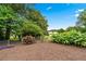 Lush backyard with vibrant landscaping, a charming garden area, and a partial privacy fence at 322 Emily Drive Sw, Lilburn, GA 30047