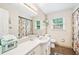 Bright bathroom featuring floral curtain and backsplash, with vanity and a large mirror at 322 Emily Drive Sw, Lilburn, GA 30047