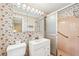 Bathroom with pink tile, large mirror, and a shower behind a sliding glass door at 322 Emily Drive Sw, Lilburn, GA 30047