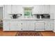Bright kitchen with white cabinets, a window over the sink, and wood floors, offering a clean and functional space at 322 Emily Drive Sw, Lilburn, GA 30047