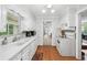 Charming white kitchen features modern appliances and ample counter space with view to living area at 322 Emily Drive Sw, Lilburn, GA 30047