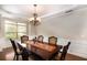 Dining room featuring hardwood flooring, large window, wainscotting, and a decorative chandelier at 3631 Guinevere Trace Trce, Douglasville, GA 30135
