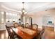 Open dining room with wood floors and modern chandelier; view to living room with many windows at 3631 Guinevere Trace Trce, Douglasville, GA 30135