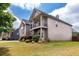 Side view of tan two-story home featuring a second story balcony with black metal railings and lawn at 3631 Guinevere Trace Trce, Douglasville, GA 30135