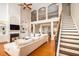 Bright living room with a large sectional, fireplace and stairs with wood treads and a balcony at 3631 Guinevere Trace Trce, Douglasville, GA 30135